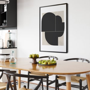 May include: A wooden dining table with a light wood finish and a black framed abstract art print above it. The table is set with a bowl of green pears and a wooden bowl with pears.