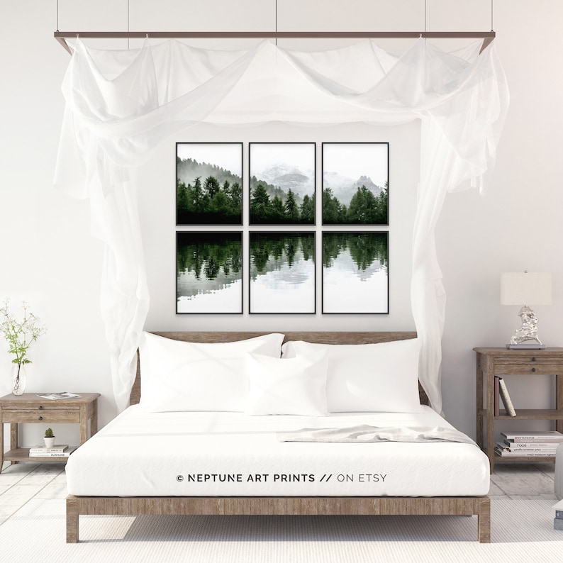 Pu&ograve; includere: Un set di sei stampe incorniciate in nero che mostrano un paesaggio scenico di un lago che riflette una foresta con montagne innevate sullo sfondo. Le stampe sono disposte in una griglia e appese a una parete bianca sopra un letto con lenzuola bianche.