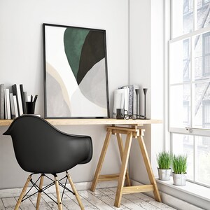 Puede incluir: Una impresi&oacute;n de arte abstracto en blanco y negro en un marco negro cuelga sobre un escritorio de madera con una silla negra y un caballete de madera. Hay dos plantas en macetas en la esquina.