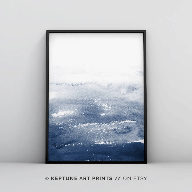 May include: A framed abstract watercolour painting in shades of blue. The painting features a gradient of blue hues, from light to dark, creating a sense of depth and movement. The painting is framed in a black frame.