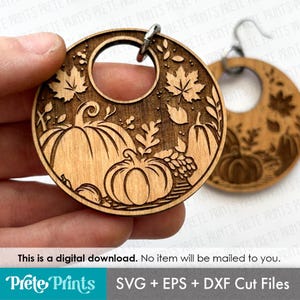 May include: Wooden earrings with a circular design featuring carved pumpkins, leaves, and a central hole. The earrings are light brown and have a detailed autumn theme. The text "This is a digital download. No item will be mailed to you." is visible.