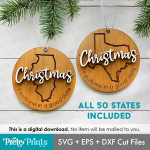 May include: Two wooden Christmas ornaments with state outlines and the word "Christmas" in white script. One ornament features the Illinois outline, the other Texas. Text reads "It puts me in a good state."