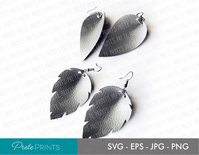 May include: A pair of silver leather earrings shaped like leaves. The earrings have a textured surface and are hanging from silver hooks.