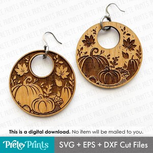 May include: Wooden round earrings with a laser-cut fall harvest design. Each earring features pumpkins, leaves, and a central circular cutout. The earrings are suspended from silver-colored ear wires. The image also includes the text: "This is a digital download. No item will be mailed to you."
