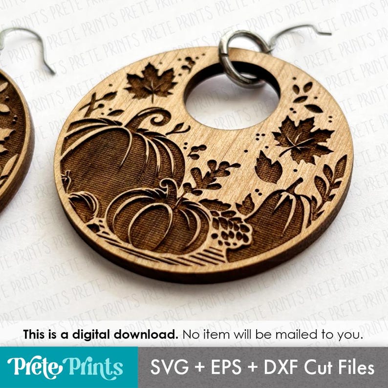 May include: Wooden earrings with a circular design featuring engraved pumpkins, leaves, and vines. The earrings have a natural wood finish and a silver-colored ear wire. The design is perfect for fall and autumn-themed accessories.
