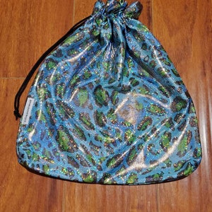 May include: A blue and green leopard print drawstring bag with a black drawstring.