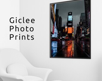 May include: A nighttime view of Times Square in New York City, with brightly lit billboards and reflections in the wet pavement.