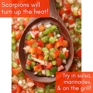 May include: Close-up of a wooden spoon filled with chopped red and green peppers. The text "Scorpions will turn up the heat!" is at the top of the image. The text "Try in salsa, marinades, & on the grill!" is at the bottom of the image.