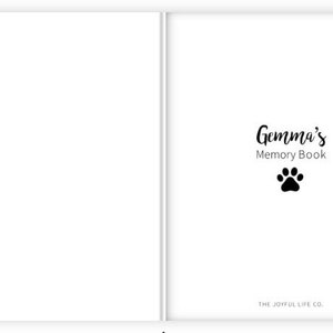May include: A white book with the text "Gemma's Memory Book" and a black paw print. The text "THE JOYFUL LIFE CO." is at the bottom of the page.