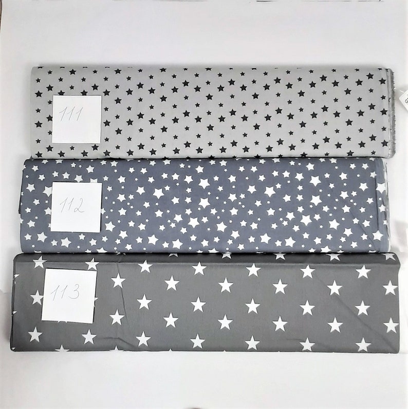 May include: Three fabric swatches with a white star pattern on a gray background. The swatches are labeled 111, 112, and 113.