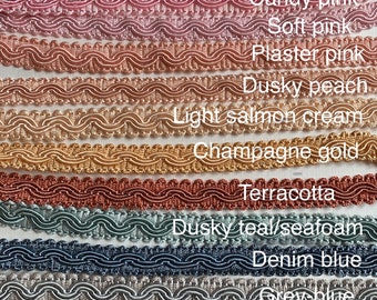 May include: A collection of 14 different colored trim cords, each with a wavy texture. The colors are burgundy, rose pink, candy pink, soft pink, plaster pink, dusky peach, light salmon cream, champagne gold, terracotta, dusky teal/seafoam, denim blue, grey blue, soft green, and dark green.
