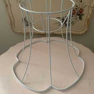 May include: White metal lampshade frame with a scalloped bottom edge.