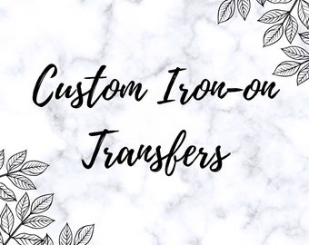 May include: White marble background with black text that reads "Custom Iron-on Transfers." Decorative black leaf designs are in the corners. The image is a promotional graphic for custom iron-on transfers.