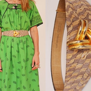 May include: A lime green dress with black leaf patterns and a tan belt with a gold buckle. The belt has a woven design and a gold buckle. The dress has short sleeves and a square neckline.