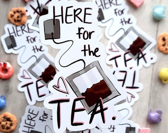 Könnte beinhalten: Ein Satz weißer Aufkleber mit einer Illustration eines Teebeutels und dem Text "Here for the tea." Die Aufkleber sind von kleinen Teekannen und anderen Dekoartikeln umgeben.