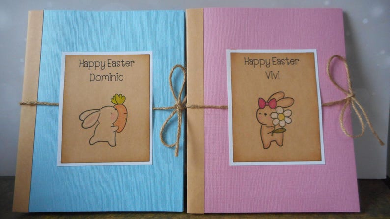May include: Two blue and pink Easter cards with brown paper wrapping and twine. The cards feature a bunny illustration and the text "Happy Easter Dominic" and "Happy Easter Vivi".