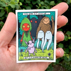 May include: A sticker featuring a comic book style illustration of four colourful creatures. The text reads "You can sit with us... but it's gonna be weird."