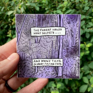 May include: Square sticker with a purple forest illustration. The text reads "THE FOREST HOLDS MANY SECRETS... AND MANY TICKS. SO MANY FUCKING TICKS." The sticker is held in a hand against a background of green leaves.