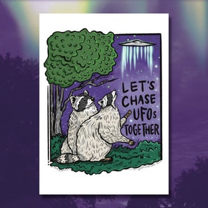 May include: Two raccoons looking up at a UFO in the night sky. The text "Let's Chase UFOs Together" is written in white letters on a purple background.