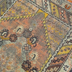May include: A vintage rug with a geometric pattern in shades of brown, orange, yellow, and white. The rug has a faded, distressed look, giving it a unique character.