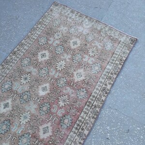 K&ouml;nnte beinhalten: Ein Vintage-L&auml;ufer mit einem verblassten rosa, cremefarbenen und blauen Blumenmuster. Der Teppich hat einen abgenutzten Look und ist perfekt, um Ihrem Zuhause einen Hauch von Boho-Stil zu verleihen.