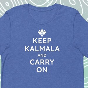 May include: A royal blue t-shirt with white text that reads "Keep Kalmala and Carry On". A small lotus flower symbol is above the text.