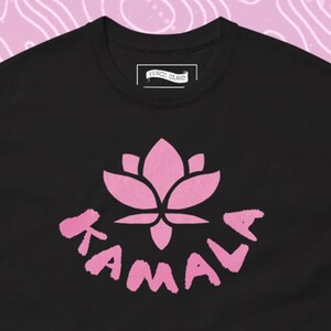 May include: Black t-shirt with a pink lotus flower and the word "KAMALA" printed on the front.
