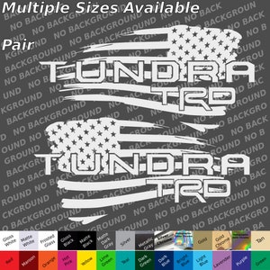 Puede incluir: Un par de calcomanías de vinilo blancas con la palabra "TUNDRA" encima de "TRD", con un diseño de bandera estadounidense desgastada. El texto "Multiple Sizes Available" está en la parte superior. Se muestran varias opciones de color en la parte inferior.