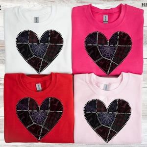 May include: Four sweatshirts in white, pink, red, and hot pink, each featuring a patchwork heart design. The heart is composed of various dark fabric patterns, including spiderwebs and other spooky elements. The word "WHITE", "RED", "PINK", and "HELICIONA" are visible.