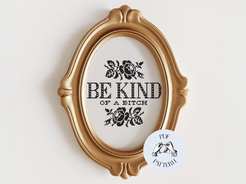 Op de afbeelding: Een ovaalvormige, goudkleurige lijst met een kruissteekontwerp. Het ontwerp toont de zwarte tekst "BE KIND OF A BITCH", omringd door bloemmotieven. Een klein PDF-patroonlogo is rechtsonder zichtbaar.