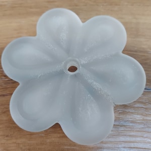 Può includere: Un apparecchio di illuminazione per soffitto in vetro smerigliato a forma di fiore con un foro al centro per il montaggio.