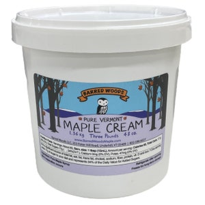May include: A white plastic container with a blue and white label that reads "Barred Woods Pure Vermont Maple Cream 1.36 kg Three Pounds 48 oz."