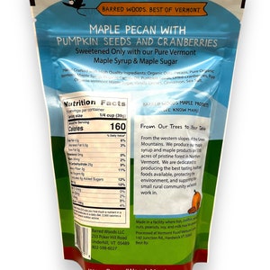 Puede incluir: Una bolsa azul y blanca de Barred Woods Maple Pecan con semillas de calabaza y ar&aacute;ndanos. La bolsa presenta una etiqueta de informaci&oacute;n nutricional y una descripci&oacute;n del producto. El producto est&aacute; endulzado con jarabe de arce puro de Vermont y az&uacute;car de arce. La bolsa tambi&eacute;n incluye una descripci&oacute;n de la empresa y su compromiso con la producci&oacute;n de productos de arce de alta calidad.