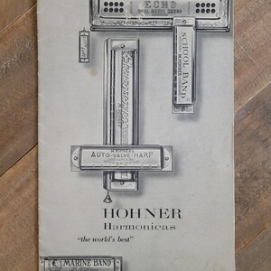 May include: An advertisement for Hohner harmonicas. The image features several harmonicas of different sizes and styles, including "Echo," "School Band," and "Marine Band." The text reads "Hohner Harmonicas" and "the world's best."