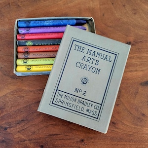 May include: A box of The Manual Arts Crayon No. 2 crayons by The Milton Bradley Co. Springfield, Mass. The box contains 8 crayons in various colours, including red, orange, yellow, green, blue, purple, and brown.
