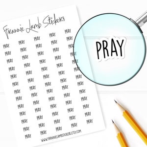 May include: A sheet of white sticker paper with the word "PRAY" repeated multiple times in black text. The stickers are arranged in a grid pattern. A magnifying glass is focused on one of the stickers.