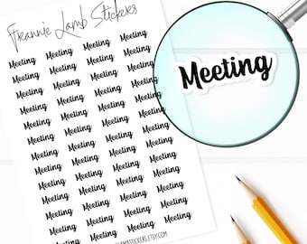 May include: A sheet of white paper with black text that reads "Freannie Lamb Stickers" and "Meeting" repeated multiple times. The text is in a handwritten font. A magnifying glass is over the sheet of paper, focusing on the word "Meeting".