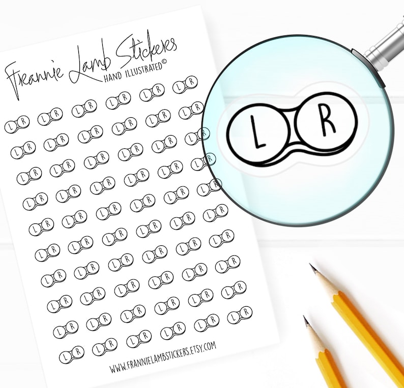 May include: A sheet of contact paper stickers with 50 black and white contact lens stickers that say "L" and "R" on them. The stickers are arranged in rows and columns. The sheet is white with the text "Freannie Lamb Stickers" and "HAND ILLUSTRATED" at the top.