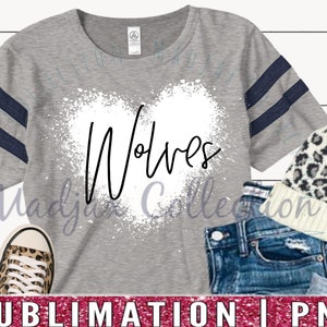 May include: A gray t-shirt with navy blue stripes on the sleeves and the word "Wolves" in a white heart-shaped design. The image also includes a pair of leopard print sneakers, a beanie, and denim shorts.
