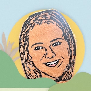 May include: A custom pi&ntilde;ata featuring a detailed black line art portrait of a person with long hair and a smiling expression. The portrait is rendered on a textured, light brown paper surface, capturing facial features including eyes, nose, and teeth.