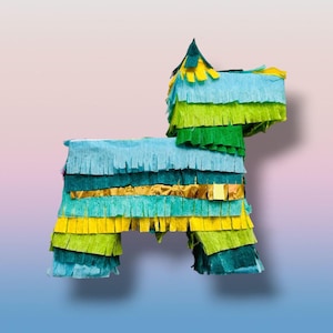 May include: A colorful dog-shaped piñata made of layered crepe paper in shades of blue, green, yellow, and gold. The piñata has a textured, fringed appearance, with a pointed head and four legs. It is set against a gradient background.