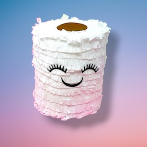 May include: A white, cylindrical piñata resembling a roll of toilet paper, decorated with a smiling face. The piñata has a brown circle on top and is fringed with white paper. The background is a gradient of blue, pink, and purple.