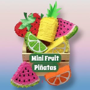 Può includere: Una collezione di mini pignatte a forma di frutta che include una fragola rossa, un ananas giallo, una fetta di anguria rosa, uno spicchio di lime verde, uno spicchio di limone giallo e una fetta d'arancia in una cassa di legno con il testo Mini Fruit Piñatas.