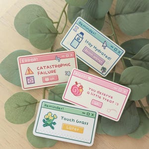 Puede incluir: Cuatro pegatinas rectangulares con diseños pixelados y texto. Una dice "Stay Hydrated! Drink water", otra dice "CATASTROPHIC FAILURE", una tercera dice "You deserve a little treat :3", y la última dice "Touch Grass Later".
