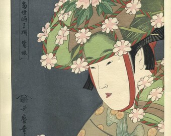 May include: Japanese woodblock print featuring a woman with pale skin and dark hair. She wears a green and brown hat adorned with pink flowers and green leaves. Her kimono is patterned with gold circles and blue wave designs. The print has Japanese text.