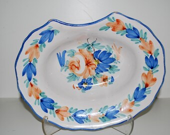 May include: White ceramic serving dish with a scalloped edge and a blue border. The dish is decorated with hand-painted orange and blue floral designs. The center of the dish features a bouquet of flowers in similar colors.