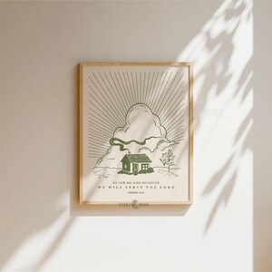 Peut inclure: Une affiche encadr&eacute;e avec une illustration verte d'une maison, de nuages et de rayons de soleil. Le texte dit : &laquo; Quant &agrave; moi et ma maison, nous servirons le Seigneur, Josu&eacute; 24:15 &raquo;. L'&oelig;uvre est dans un cadre en bois.