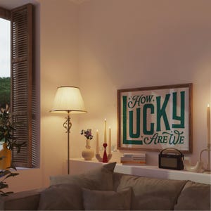 May include: A cozy living room scene featuring a floor lamp with a cream-colored lampshade, a framed artwork with the text "How Lucky Are We", and a small radio. The room is illuminated by warm lighting and candles.