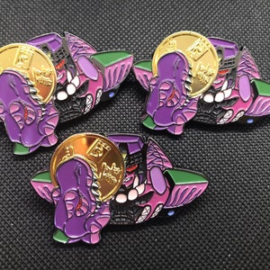 May include: Three enamel pins featuring a purple and black robot holding a gold coin. The robot has a menacing expression and sharp teeth. The coin has Japanese characters on it.