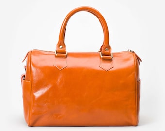 May include: A bright orange leather satchel bag with two top handles and a zipper closure.
